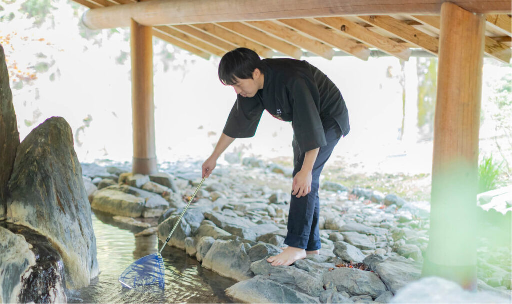 網でお風呂のゴミを取る男性清掃スタッフ